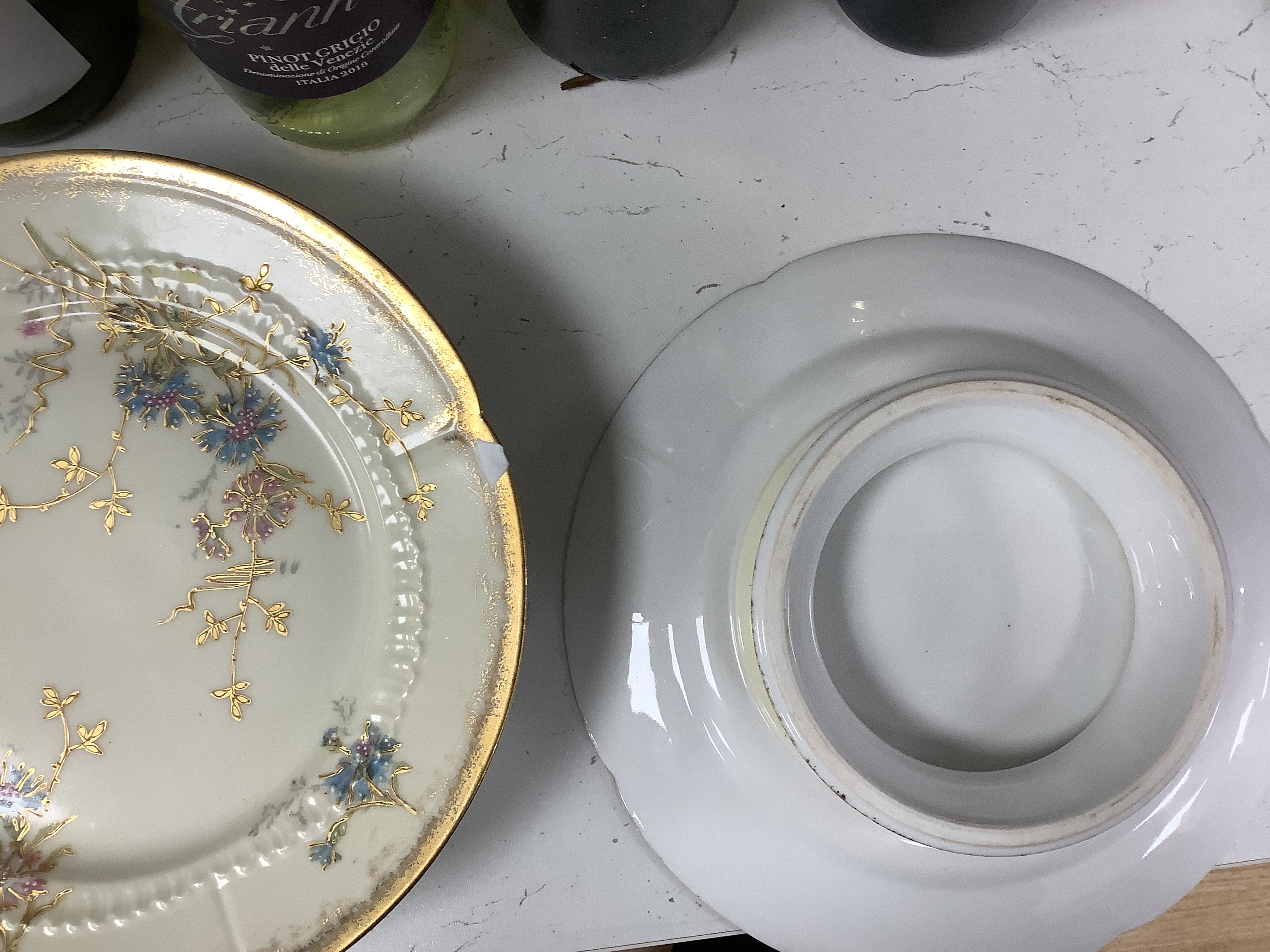 Thirteen Limoges style porcelain dessert plates, two on pedestal bases, gilt decorated with cornflowers etc., 24.5cm diameter